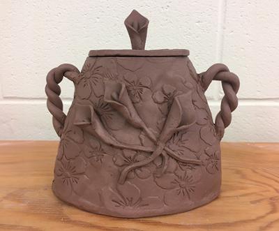 An ornate clay jar made by a student