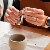 A student handbuilds a ceramic mug