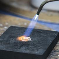 A student uses a torch on a silver ring