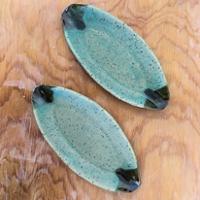 A pair of pottery trays on a wooden tabletop