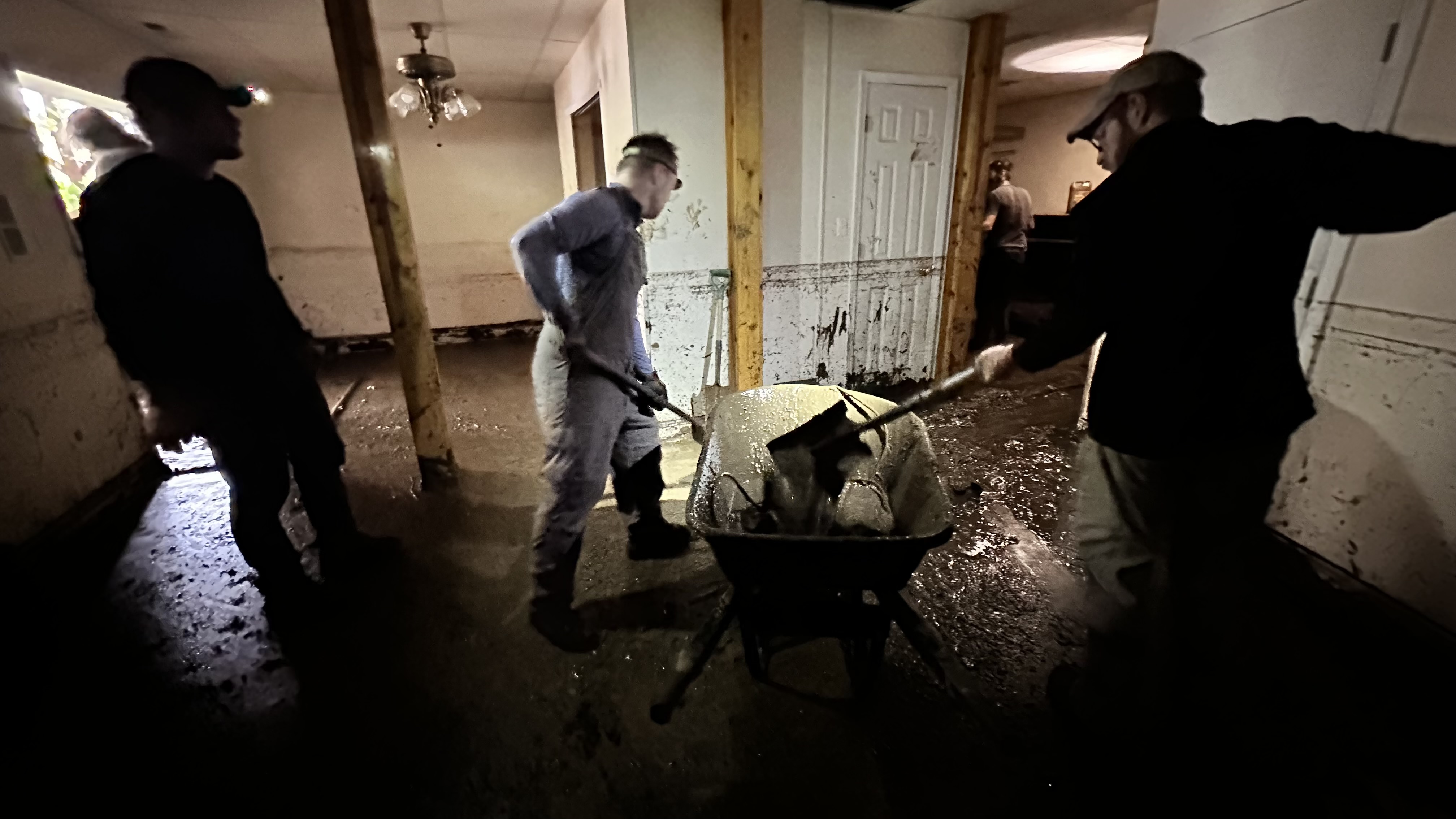 forestry students cleaning mud out of a home